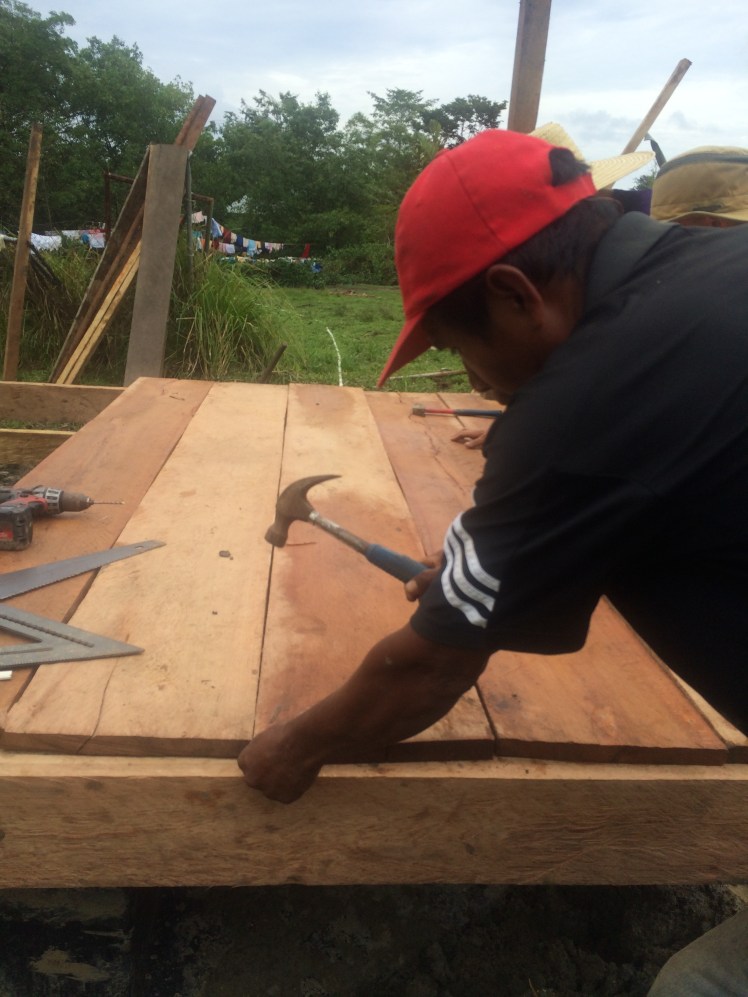 Francisco's family came through with the wood! Here is Simon attaching the floorboards 